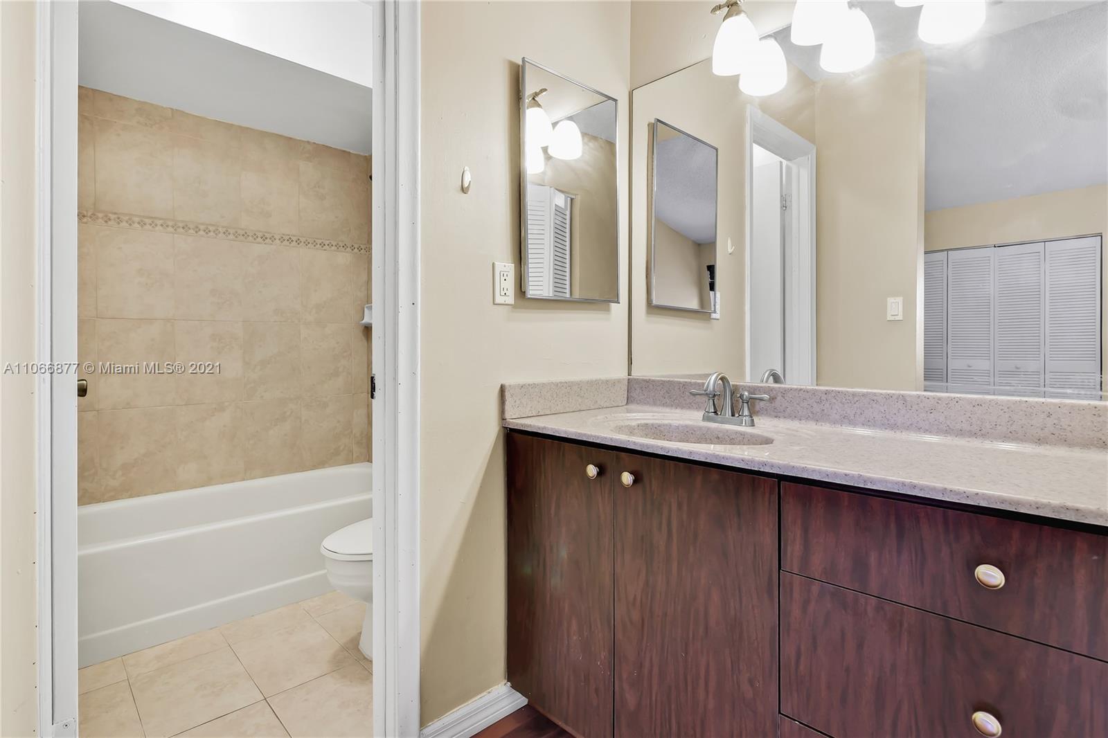 11820 Southwest 80th Street, Unit 312 Miami, FL 33183 - Photo 31 of 43 a bathroom with a sink a toilet and shower