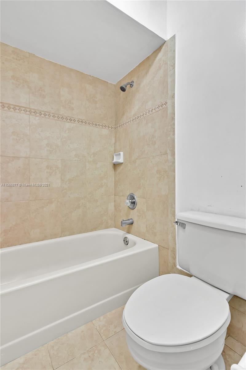 11820 Southwest 80th Street, Unit 312 Miami, FL 33183 - Photo 32 of 43 a white toilet sitting next to a bath tub and a shower