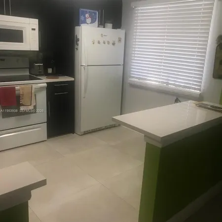 a kitchen with a refrigerator and a stove