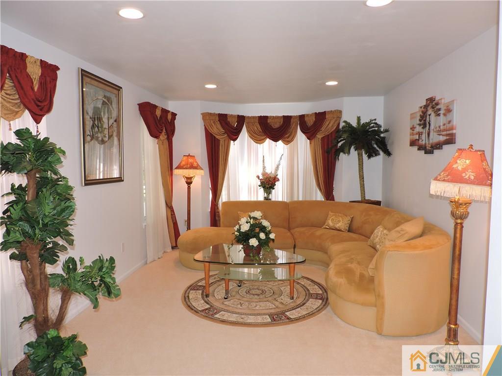 236 Hawthorne Road North Brunswick, NJ 08902 - Photo 2 of 25 a dining room with furniture potted plants and a chandelier