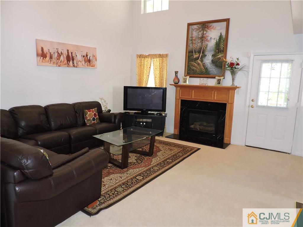 236 Hawthorne Road North Brunswick, NJ 08902 - Photo 6 of 25 a living room with furniture a flat screen tv and a fireplace