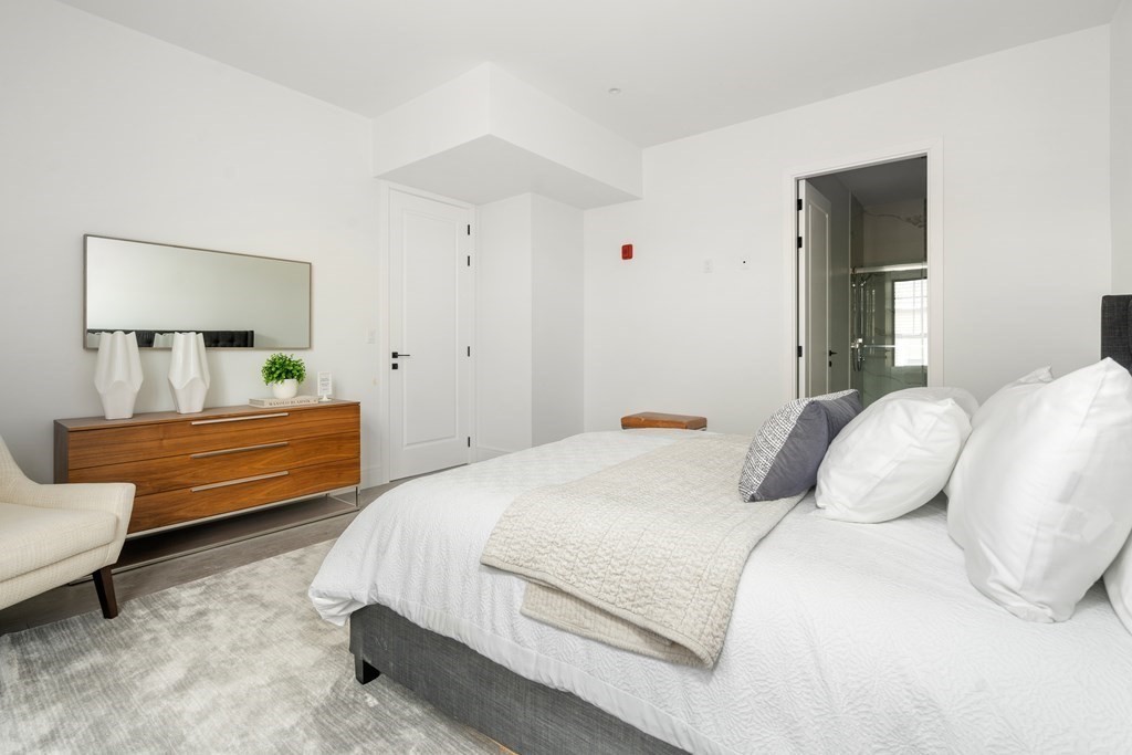 8 Leverett Street, Unit 1 Brookline, MA 02445 - Photo 5 of 29 a bedroom with a bed and a lamp on dresser