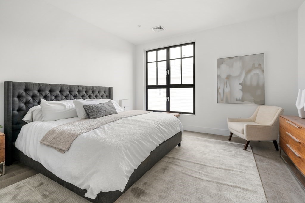 8 Leverett Street, Unit 1 Brookline, MA 02445 - Photo 8 of 29 a large bed sitting in a bedroom next to a window