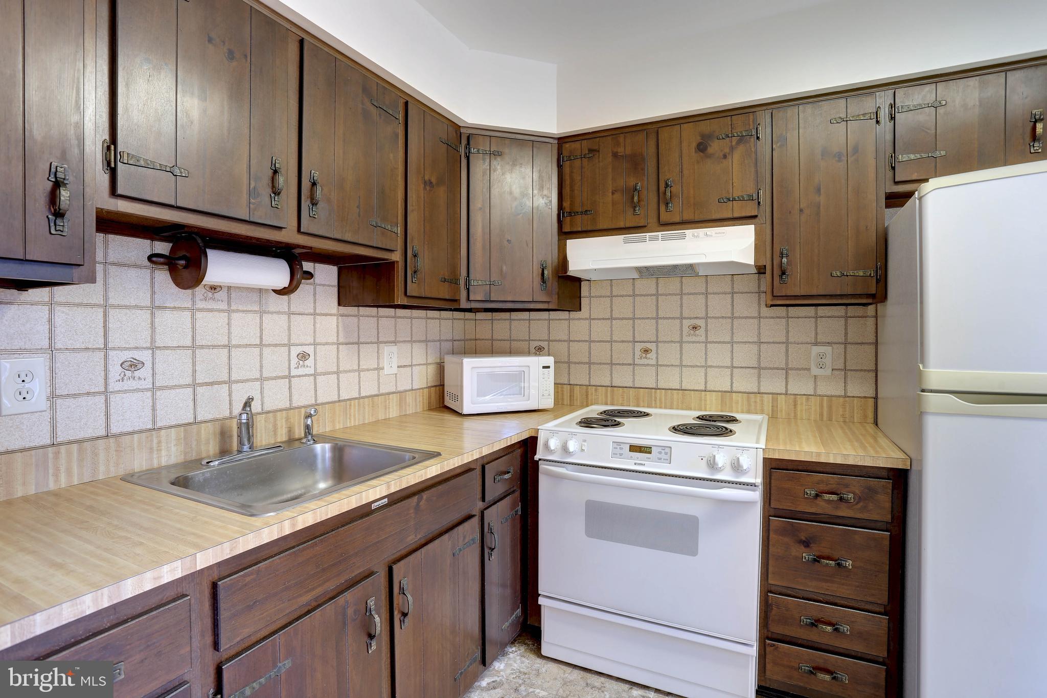 207 Greenland Beach Road Baltimore, MD 21226 - Photo 12 of 28 a kitchen with a sink stove and cabinets