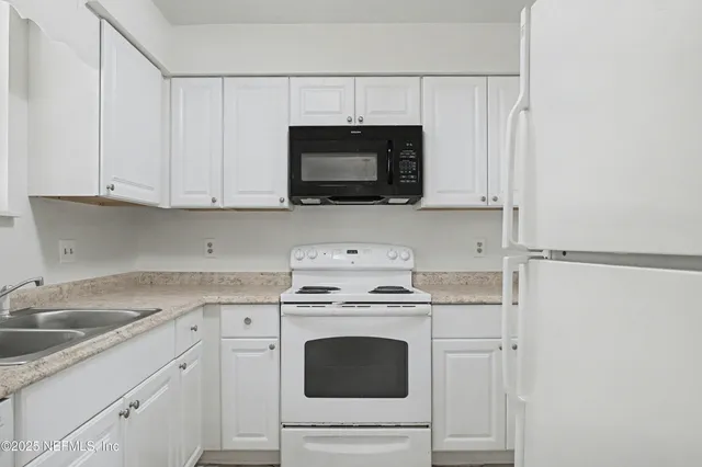 a kitchen with cabinets stainless steel appliances and a sink
