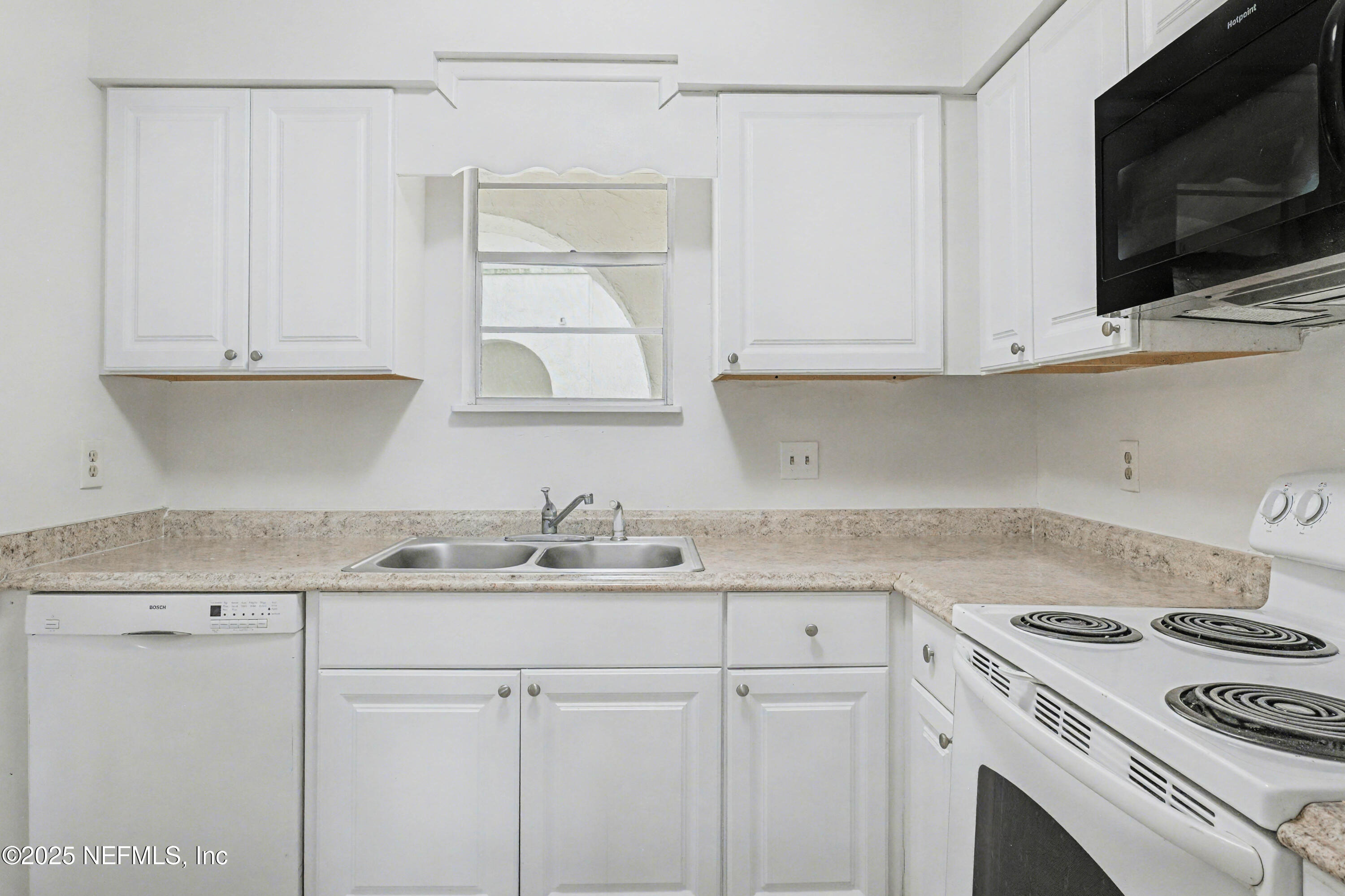 1530 El Prado Road, Unit 1 Jacksonville, FL 32216 - Photo 5 of 15 a kitchen with granite countertop white cabinets and white appliances