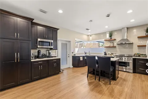 a kitchen with kitchen island granite countertop wooden cabinets and stainless steel appliances