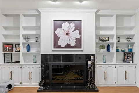 a living room with white cabinets and a fireplace