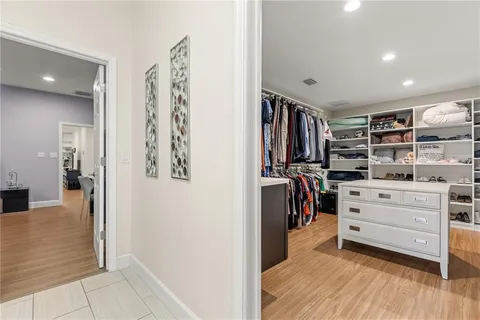 a view of walk in closet with clothes and shoes