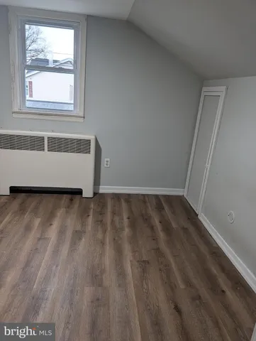 a view of a room with wooden floor and a window