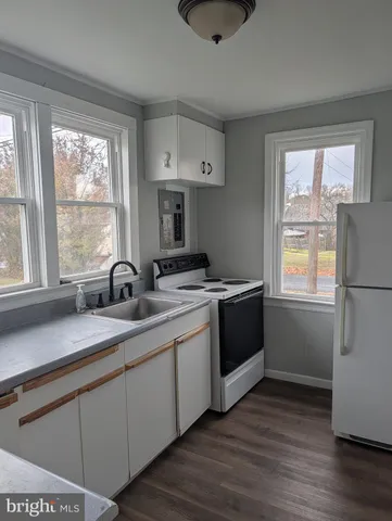 a kitchen with a sink cabinets and wooden floor
