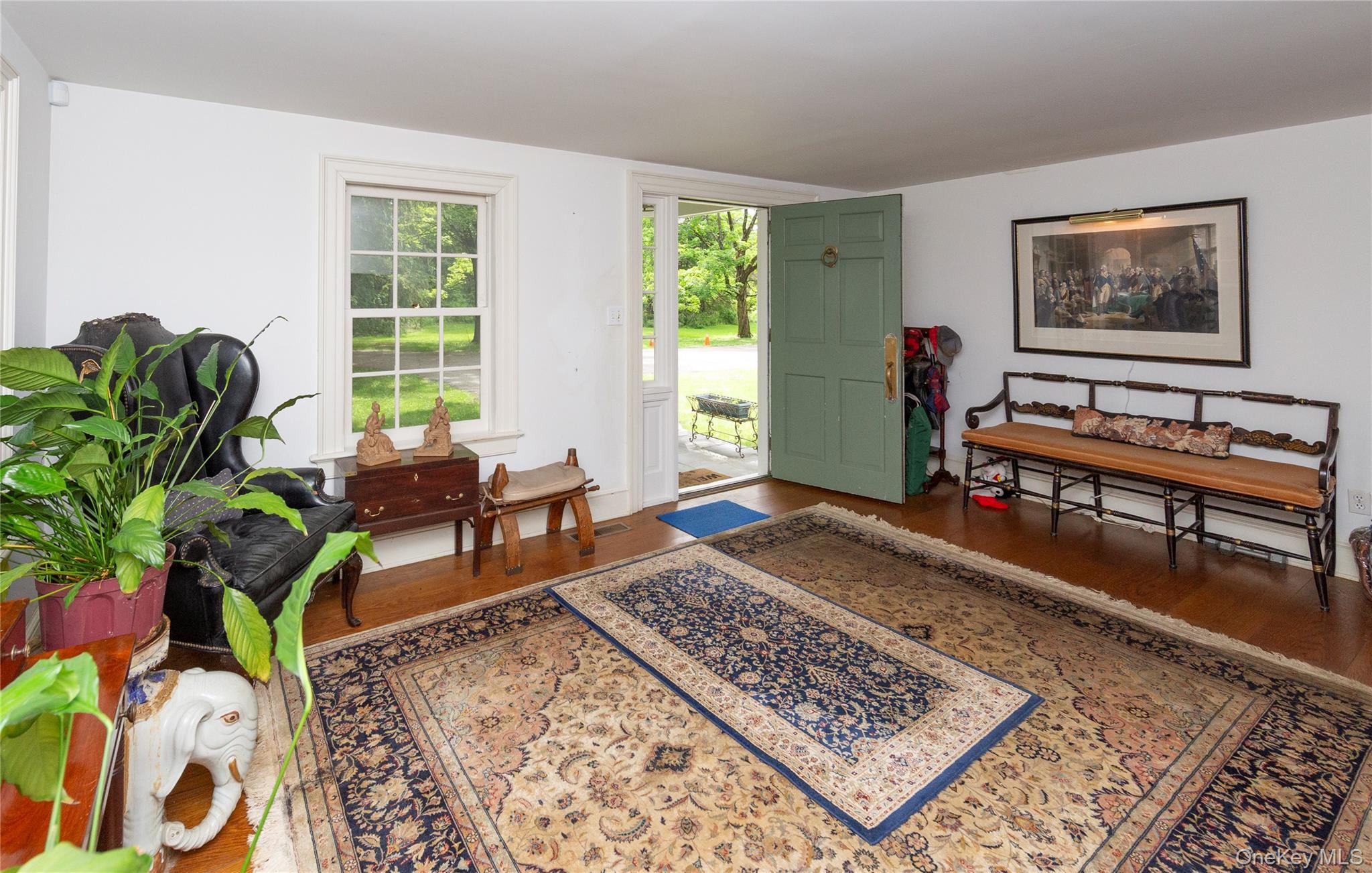 64 South Quaker Hill Road Pawling, NY 12564 - Photo 11 of 41 Entryway featuring a paneled front door, hardwood flooring, white trim, and a window providing natural light