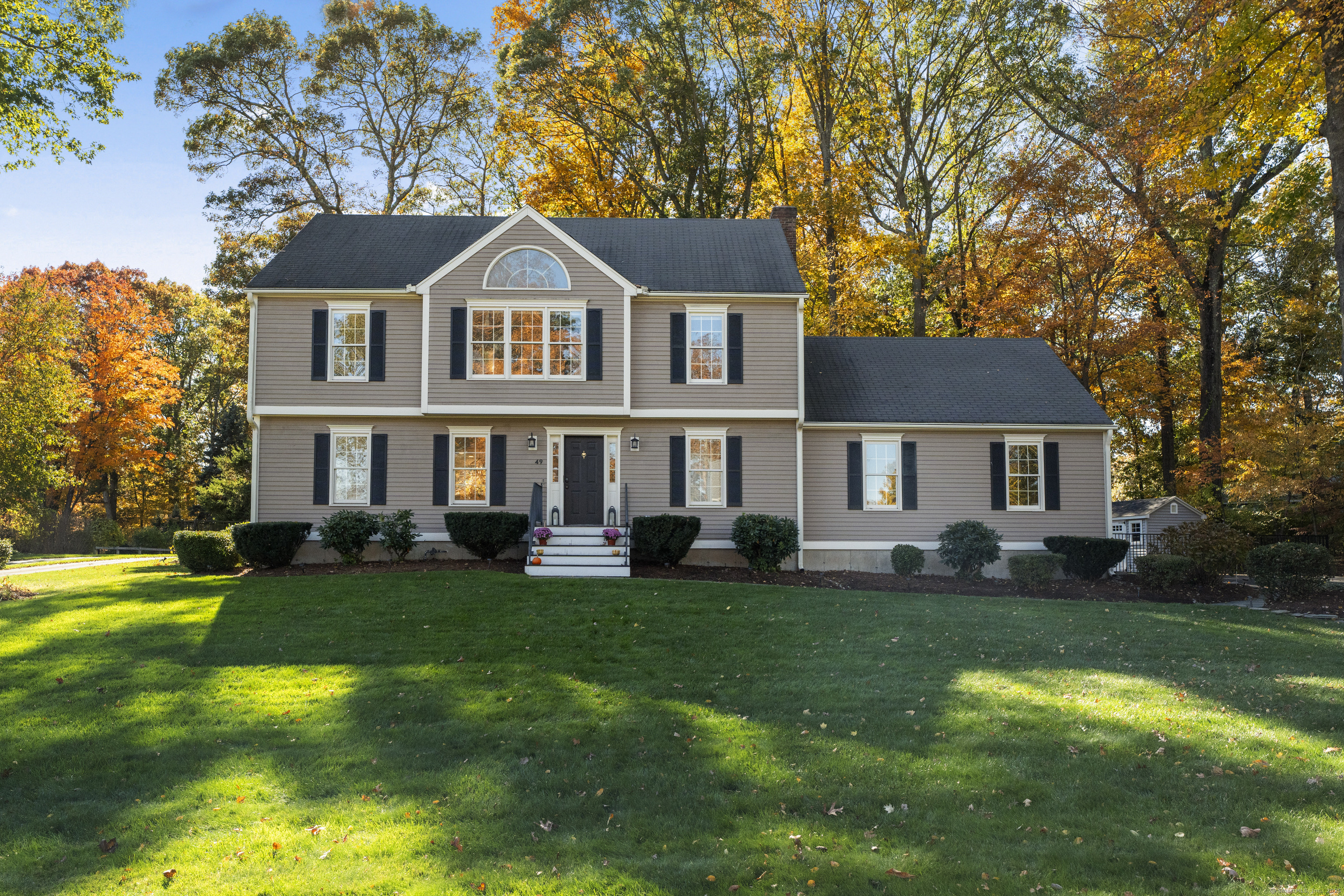 49 Riverside Drive Branford, CT 06405 - Photo 1 of 1 a front view of a house with a garden and trees