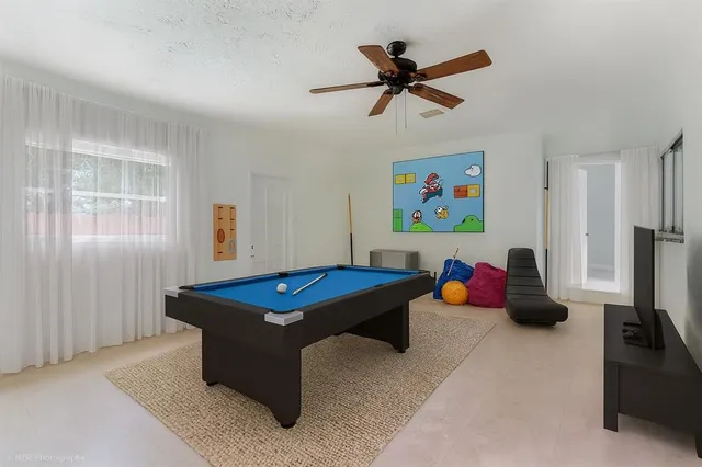 a room with pool table and windows