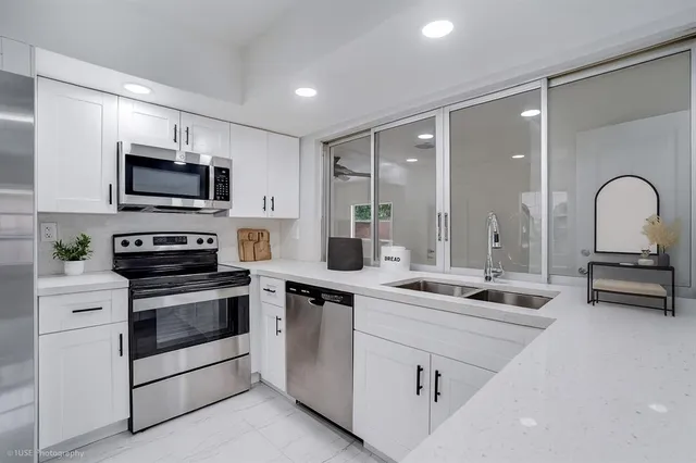 a kitchen with appliances a sink and cabinets