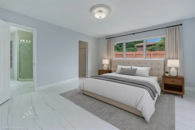 a bedroom with a bed and a large window