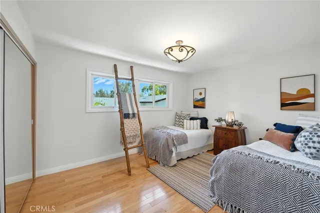 a bedroom with two beds and painting on the wall