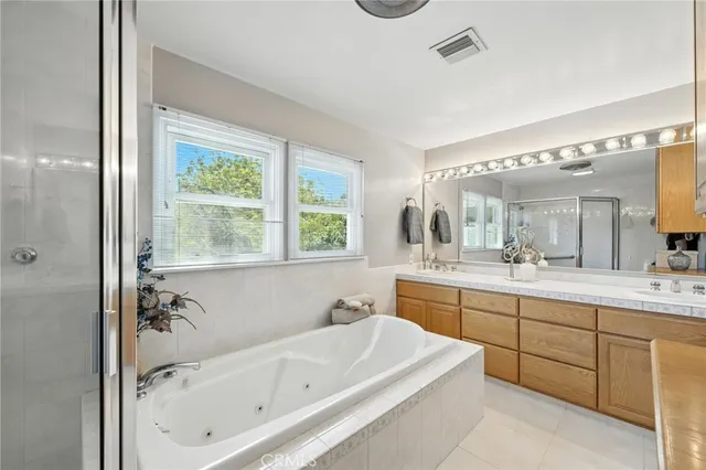 a bathroom with a tub sink and mirror