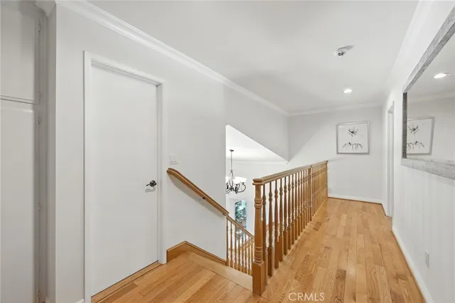 a view of a hallway with wooden floor and stairs