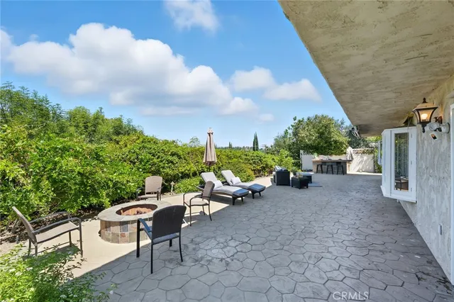 a view of a patio with furniture and a garden