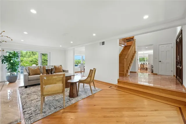 a living room with furniture a wooden floor and next to a window