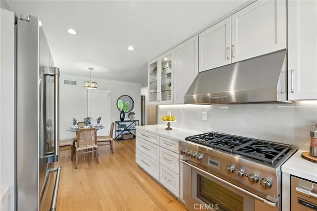 a kitchen with a stove a refrigerator and cabinets