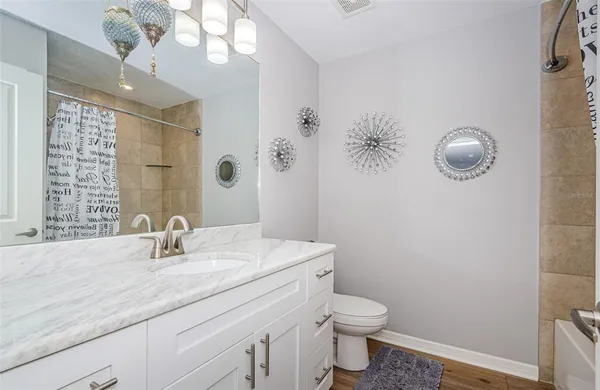a bathroom with a granite countertop sink a toilet and mirror