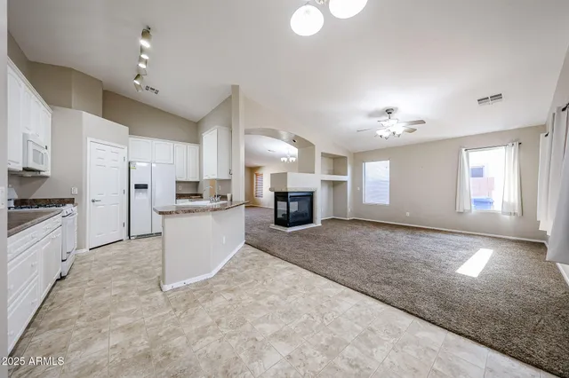 a kitchen with granite countertop a stove a sink and a refrigerator