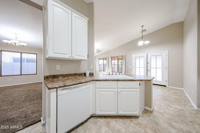 a kitchen with granite countertop white cabinets and a sink