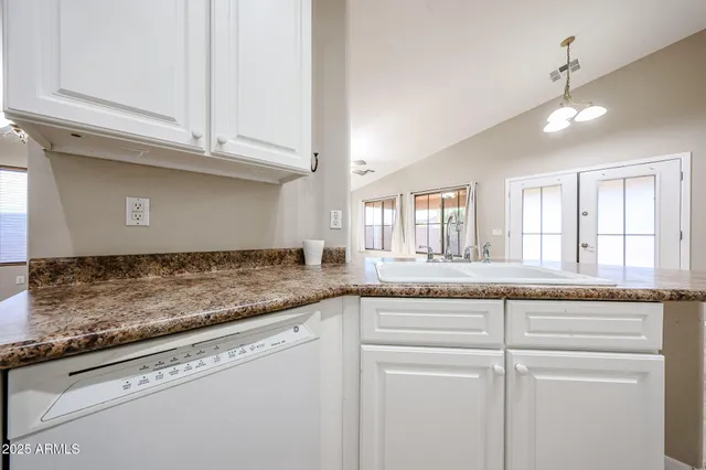 a bathroom with a granite countertop sink and white cabinets