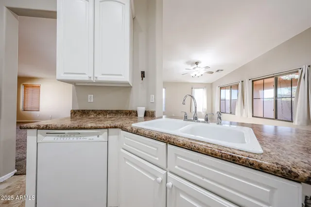 a kitchen with granite countertop white cabinets and appliances