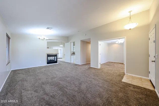 an empty room with fireplace and cabinet