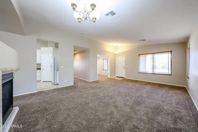 an empty room with windows and fireplace
