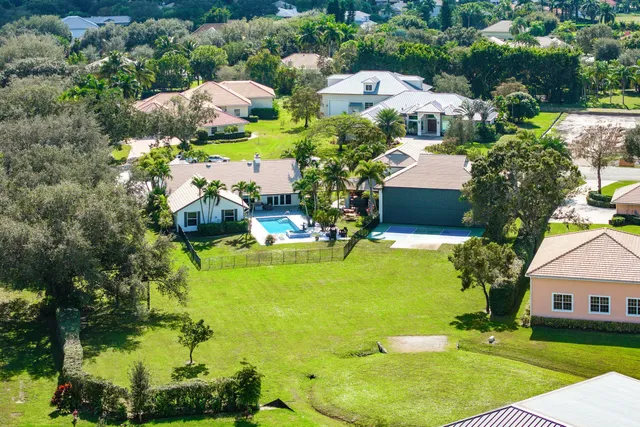 an aerial view of residential houses with outdoor space and swimming pool
