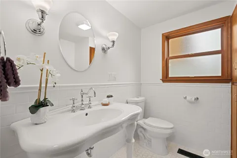 a bathroom with a sink a toilet and a mirror