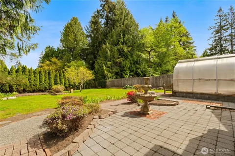 a view of a backyard with lawn chairs potted plants and swimming pool