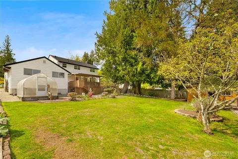 a view of a house with a big yard and large trees
