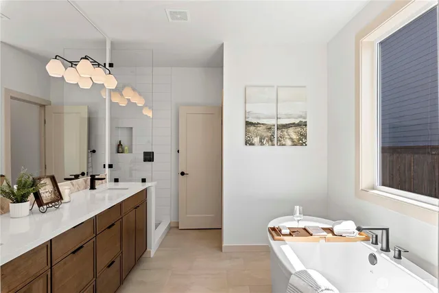 a bathroom with a sink a large mirror and a bathtub