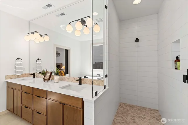 a bathroom with a sink a mirror and a shower