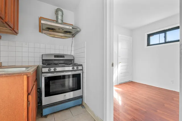 a view of a kitchen with stainless steel appliances wooden floor and stove