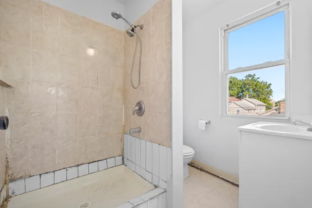 a bathroom with a tub a sink a window and a shower