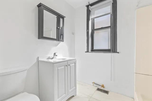 a bathroom with a sink mirror and toilet