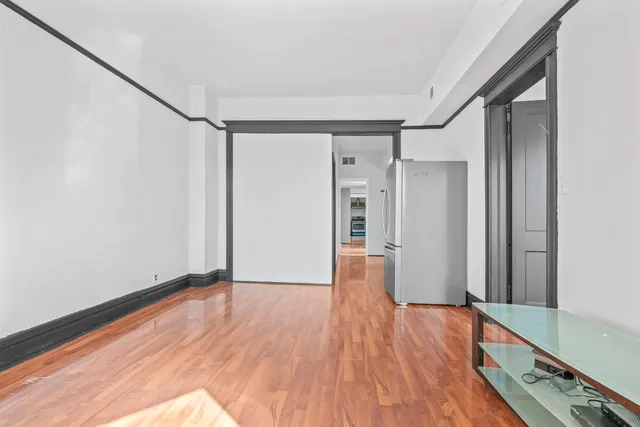 a view of empty room with wooden floor