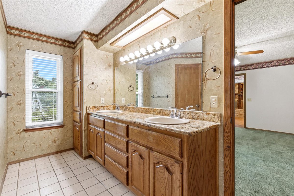 250 Hickory Drive Elgin, TX 78621 - Photo 16 of 37 a bathroom with a granite countertop sink a large mirror and a shower