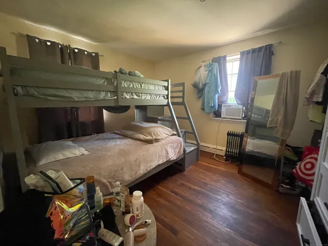 a bedroom with a bed a mirror and dresser