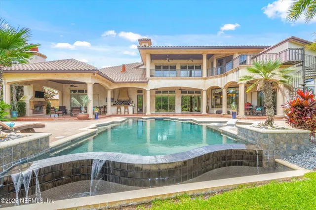 a living room with furniture a chandelier and a potted plant
