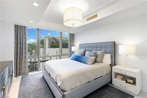 a bedroom with a large bed and a chandelier