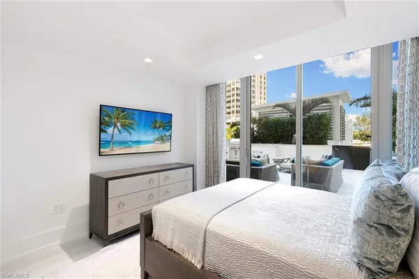 a bedroom with a large bed and a large mirror