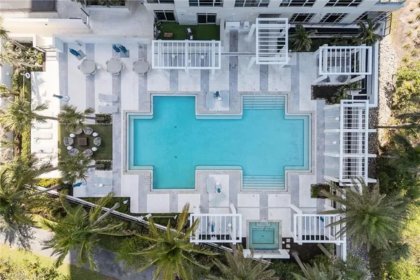 an aerial view of ocean and residential houses with outdoor space