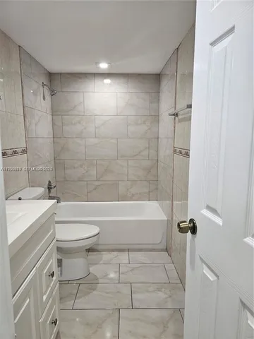 a bathroom with a toilet a sink a mirror and bathtub